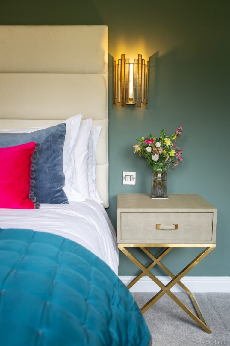 Dusty green walls complement the teal accessories in this relaxing bedroom
