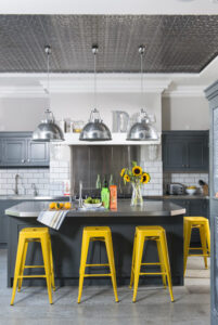 Vibrant yellow stools add a jolt of colour to this industrial style kitchen