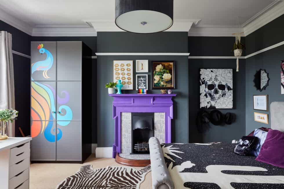 Dark grey walls and purple fireplace create a stunning teenage bedroom with black patterned duvet cover