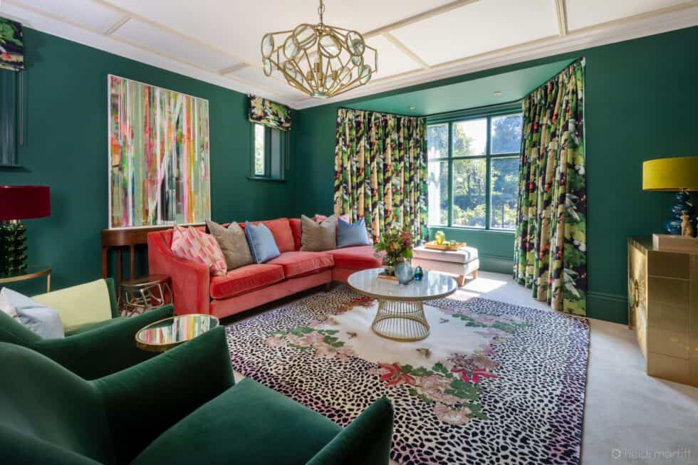 Bottle green walls, statement art, a floral rug and patterned curtains create the perfect background for this coral L shaped sofa