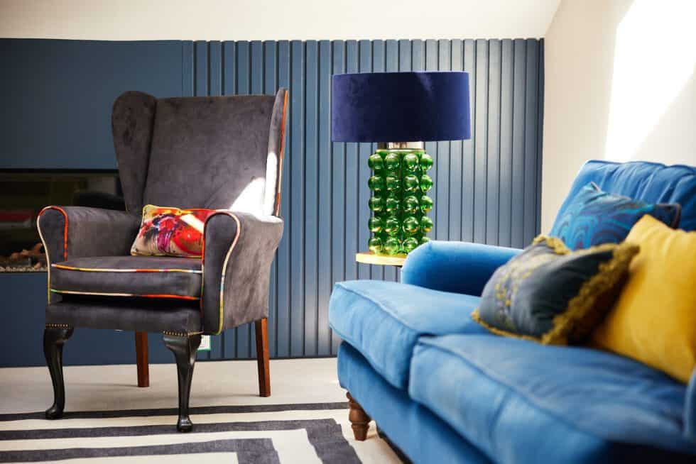 Bespoke storage, a reupholstered wingback chair and a rich blue sofa make for a perfect sitting room