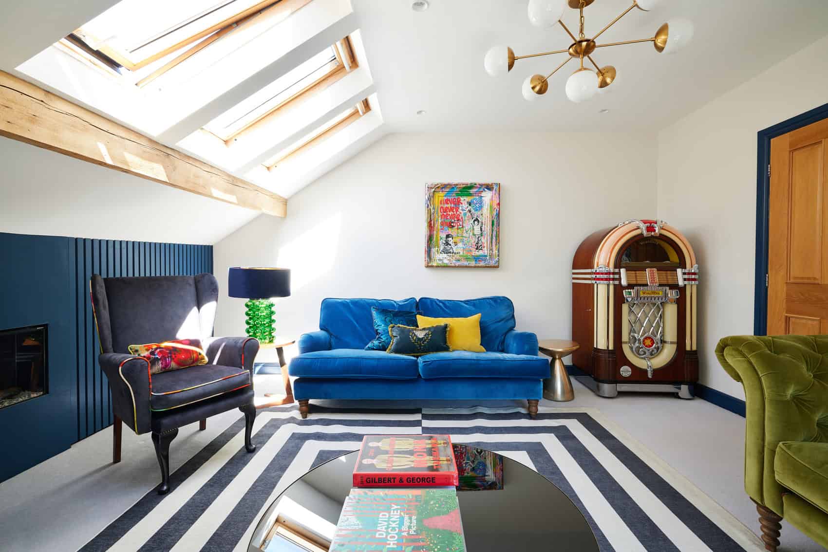 ILKLEY4_AMC_JUNE2023 58 Art and colourful sofas add personality to an airy attic apartment sitting room, while a geometric rug provides contrast