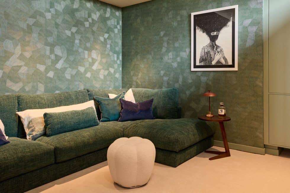 Home cinema and snug with green textured wallpaper from Arte and green sofa